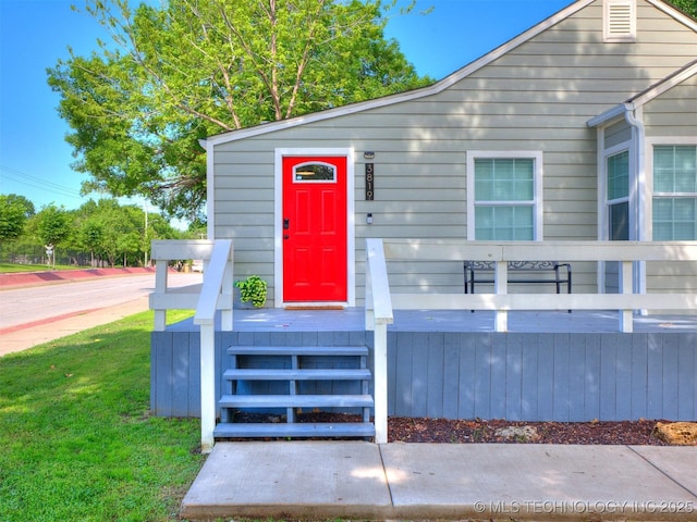 view of exterior entry with a lawn