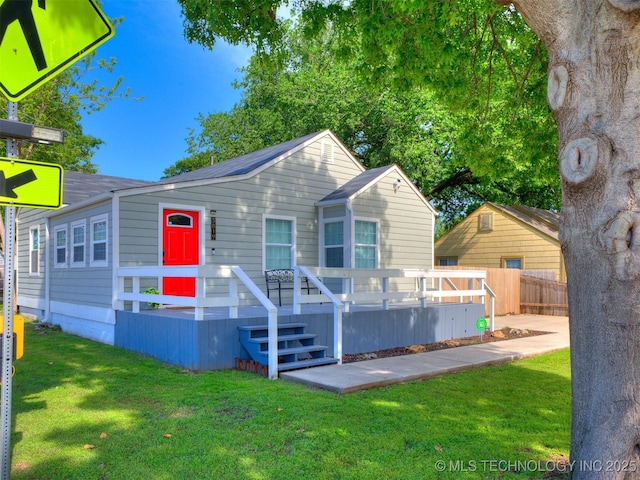 view of front of property featuring fence, a wooden deck, and a front lawn