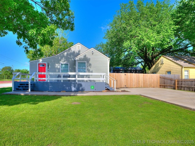 back of house with fence, a wooden deck, and a yard