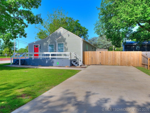 view of front of home with a front lawn, fence, and a wooden deck