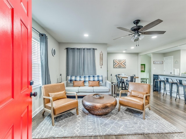 living area with baseboards, a ceiling fan, recessed lighting, and wood finished floors