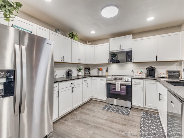 kitchen featuring recessed lighting, a sink, light wood finished floors, and appliances with stainless steel finishes