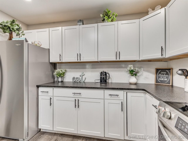 kitchen with light wood-type flooring, white cabinetry, and appliances with stainless steel finishes