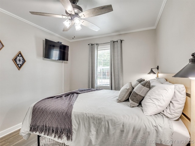 bedroom with crown molding, a ceiling fan, baseboards, and wood finished floors