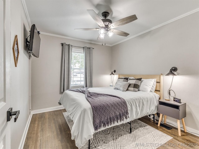 bedroom featuring crown molding, baseboards, and wood finished floors