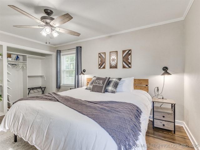 bedroom with crown molding, ceiling fan, baseboards, wood finished floors, and a closet