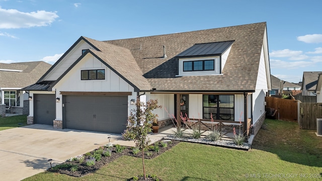 view of front facade featuring covered porch, fence, driveway, and a front yard