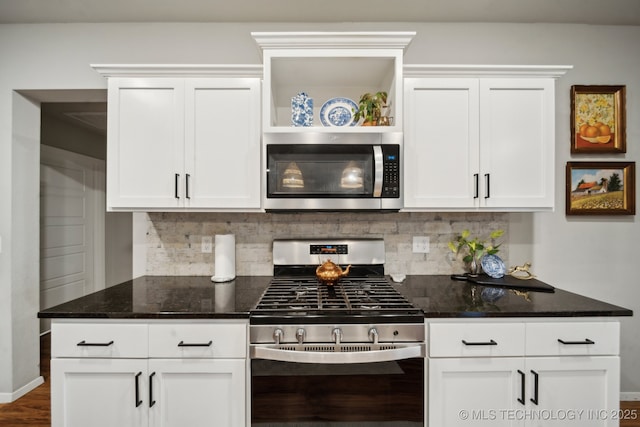 kitchen with decorative backsplash, dark stone counters, appliances with stainless steel finishes, and white cabinets