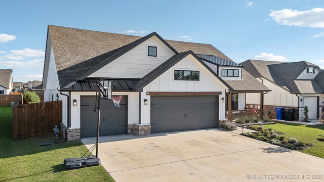 view of front of home featuring a front lawn, fence, roof with shingles, board and batten siding, and driveway