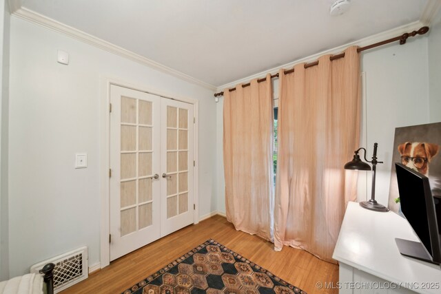 doorway with ornamental molding, french doors, light wood-type flooring, and visible vents