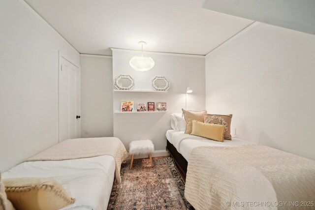 bedroom featuring crown molding and wood finished floors