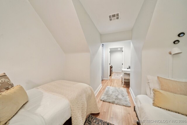 bedroom with visible vents, light wood-style floors, and baseboards