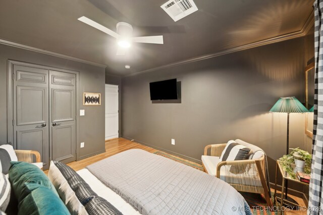 bedroom with visible vents, ornamental molding, baseboards, and light wood-type flooring