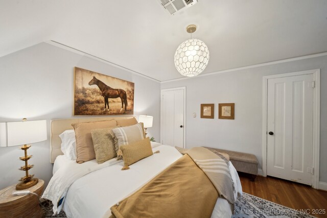 bedroom featuring visible vents, crown molding, and wood finished floors