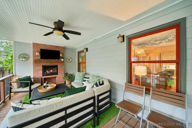 exterior space featuring a ceiling fan and an outdoor living space with a fireplace