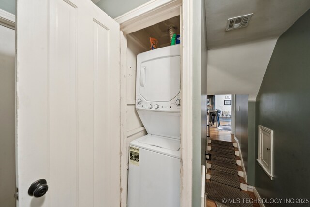 laundry area featuring stacked washing maching and dryer, laundry area, and visible vents