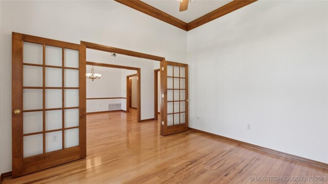 9219 N 134th E Ave, Owasso, OK 74055 - unfurnished room featuring a chandelier, light wood finished floors, french doors, crown molding, and baseboards