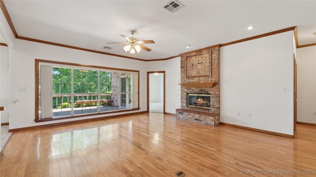 9219 N 134th E Ave, Owasso, OK 74055 - unfurnished living room with a ceiling fan, hardwood / wood-style flooring, baseboards, a brick fireplace, and crown molding