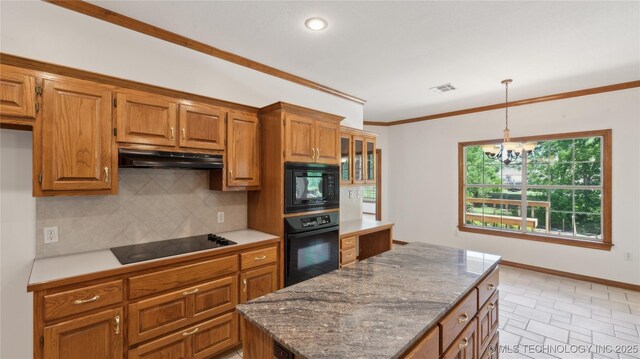 9219 N 134th E Ave, Owasso, OK 74055 - kitchen with black appliances, under cabinet range hood, backsplash, a chandelier, and brown cabinets