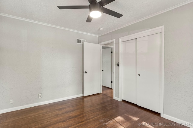 unfurnished bedroom with a textured ceiling, a ceiling fan, wood finished floors, visible vents, and ornamental molding