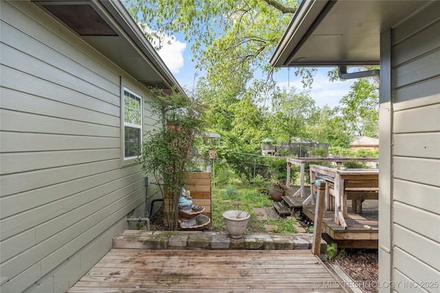 view of side of home with fence and a deck