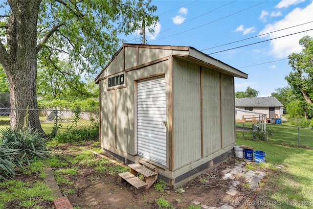 view of outbuilding featuring fence and an outbuilding