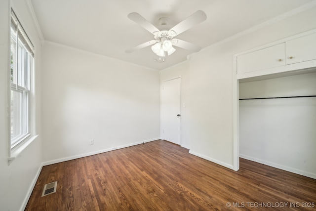unfurnished bedroom featuring a ceiling fan, baseboards, wood finished floors, visible vents, and a closet