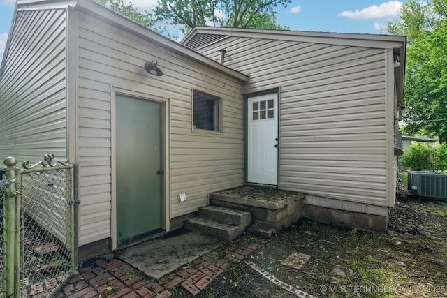 back of property with fence, central AC unit, and entry steps