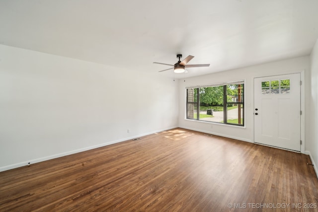 interior space featuring baseboards, ceiling fan, and wood finished floors