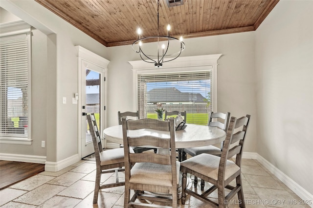 dining space featuring stone tile floors, crown molding, and wooden ceiling