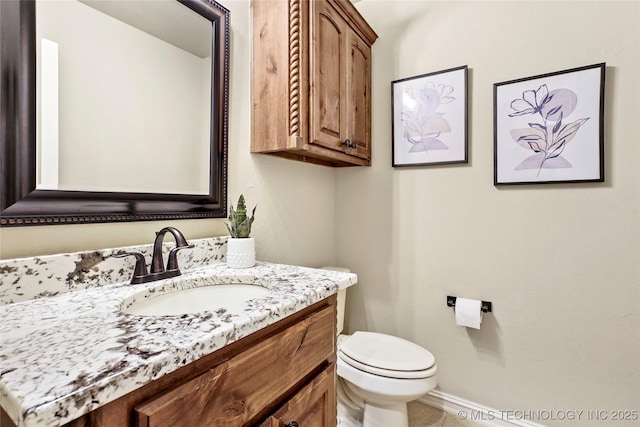 bathroom featuring vanity, baseboards, and toilet