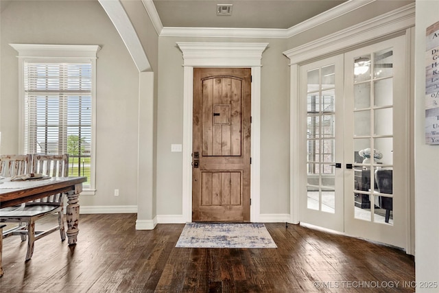entrance foyer with baseboards, visible vents, arched walkways, and dark wood-type flooring