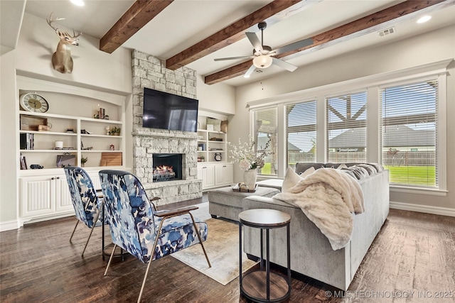 living area with wood finished floors, a ceiling fan, a wealth of natural light, and a fireplace