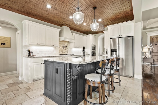 kitchen featuring premium range hood, wood ceiling, white cabinets, a sink, and stainless steel appliances