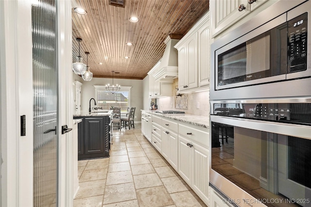 kitchen with recessed lighting, light stone counters, white cabinets, and stainless steel appliances