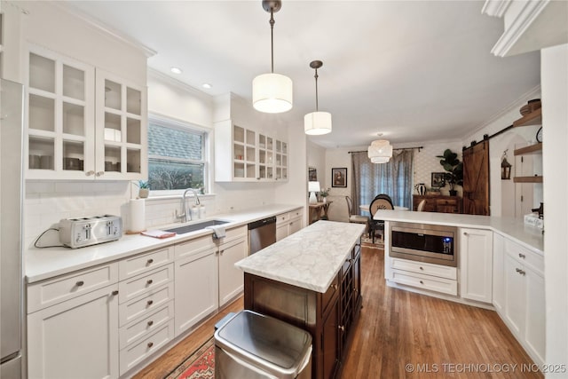 2252 S Troost Ave, Tulsa, OK 74114 - kitchen featuring light wood-style floors, a sink, appliances with stainless steel finishes, and a barn door