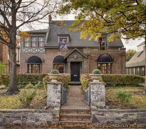 2252 S Troost Ave, Tulsa, OK 74114 - tudor house with a chimney and brick siding
