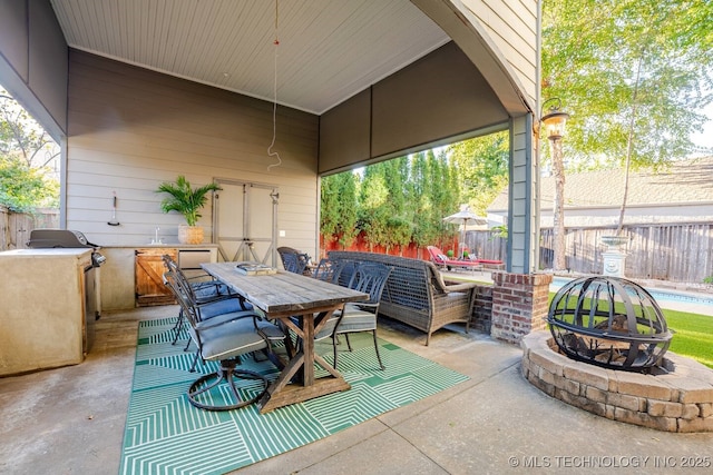 2252 S Troost Ave, Tulsa, OK 74114 - view of patio / terrace with a fenced backyard, a sink, outdoor dining space, and a fire pit