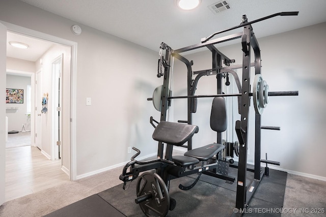 workout area featuring baseboards, carpet, and visible vents