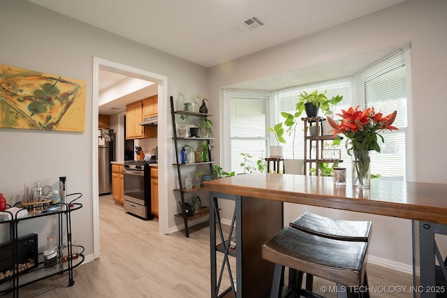 interior space featuring baseboards, visible vents, and light wood finished floors