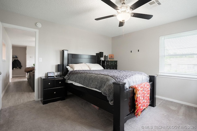 carpeted bedroom with visible vents, a ceiling fan, and baseboards