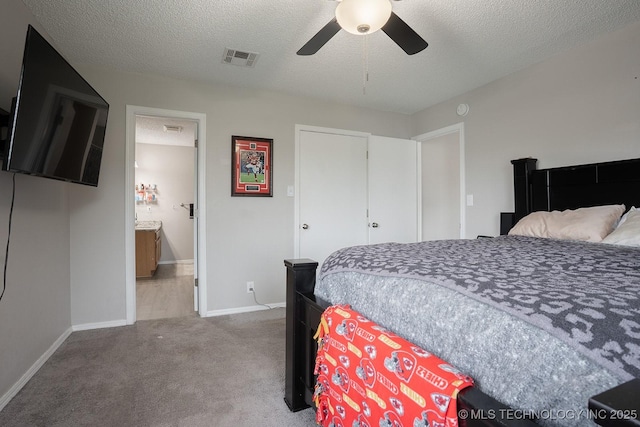 carpeted bedroom with visible vents, a textured ceiling, baseboards, and a ceiling fan