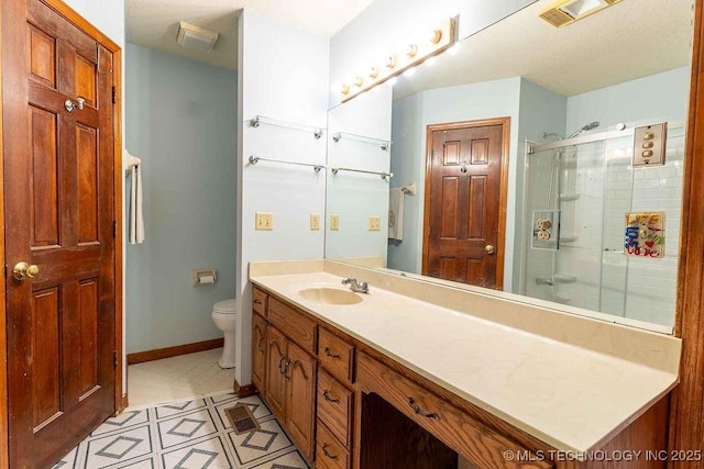 full bath with vanity, toilet, baseboards, a shower with door, and visible vents