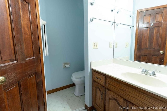 bathroom featuring toilet, baseboards, tile patterned floors, and vanity