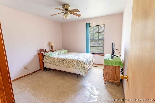 carpeted bedroom featuring baseboards, a ceiling fan, and visible vents