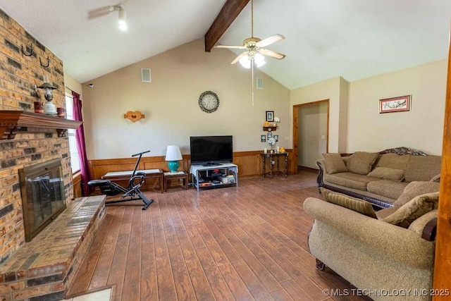living area with ceiling fan, visible vents, a fireplace, beamed ceiling, and dark wood-style floors