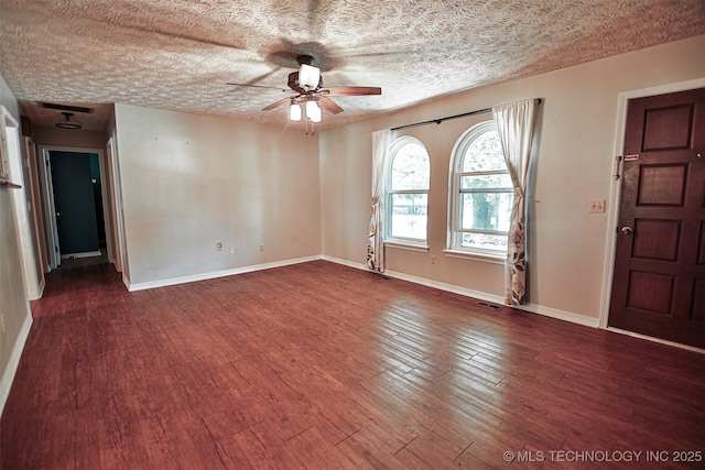 spare room featuring visible vents, baseboards, ceiling fan, and wood finished floors