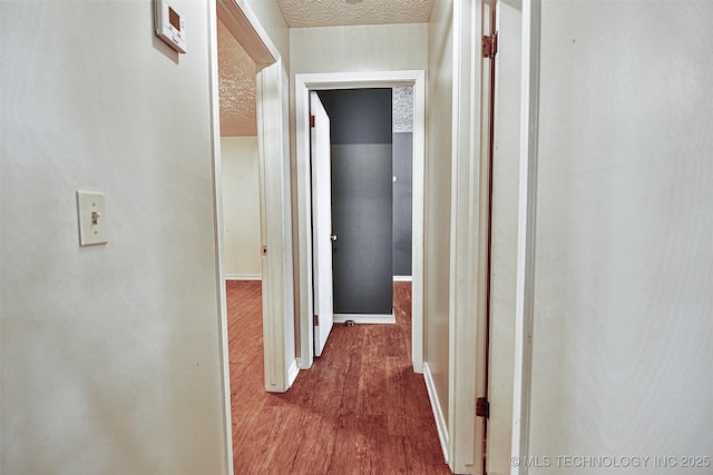 hall featuring baseboards and dark wood-style floors