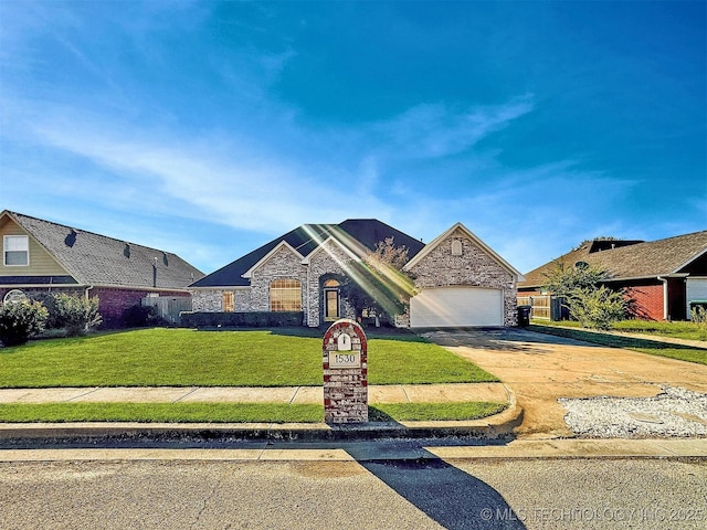 view of front of house with stone siding, concrete driveway, a front lawn, and a garage