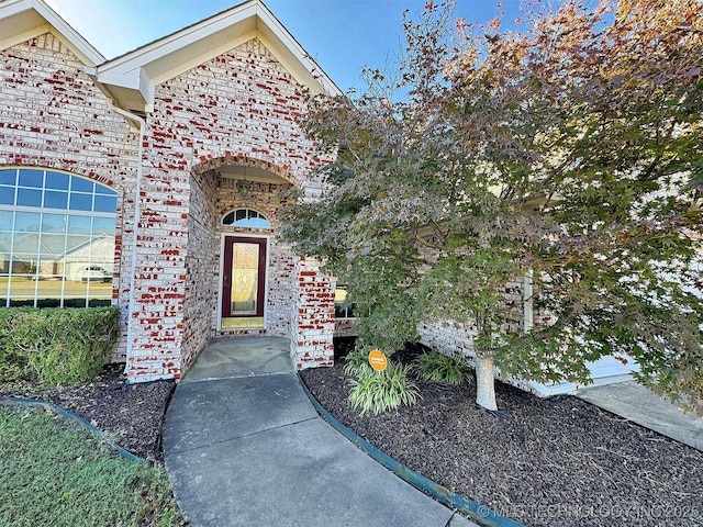 view of exterior entry with brick siding